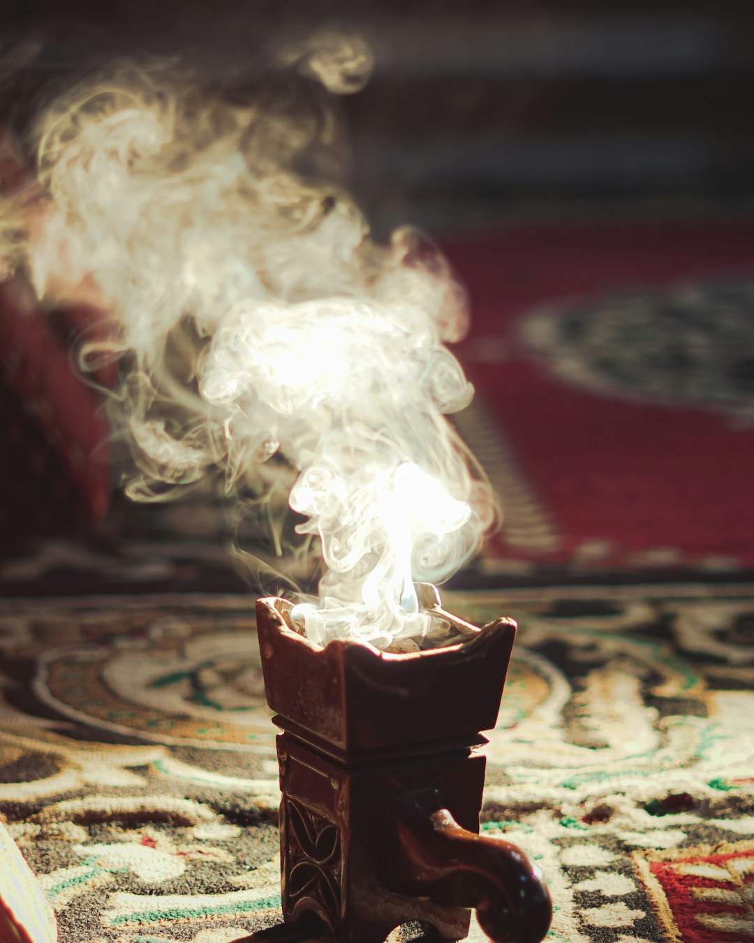 Arzator de oud pe covor cu fum ridicandu-se - ritual traditional al lemnului de agar - Little Paris Atelier